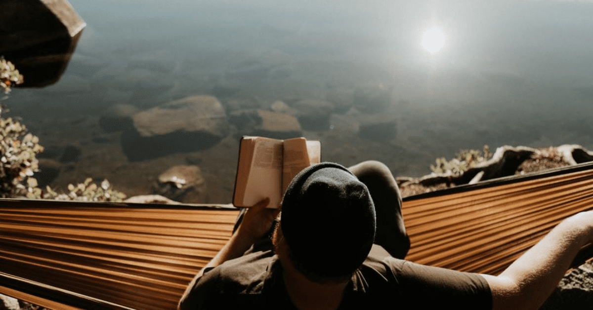 A man is reading while sitting on the ground